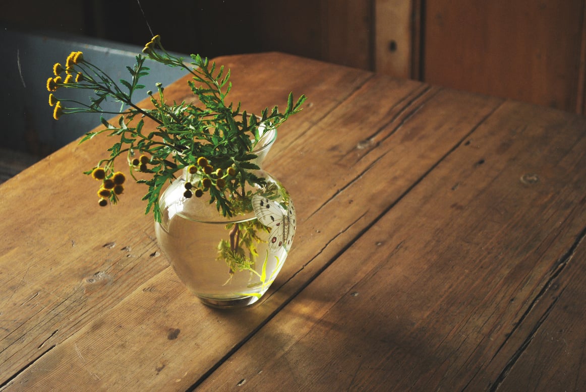 Vase with wild flowers on table